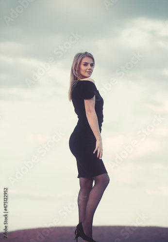 Pretty girl, nice face. Lovely soft back light. View on city buildings and roofs.