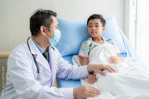 a boy who is reclining in the hospital being encouraged by the doctor