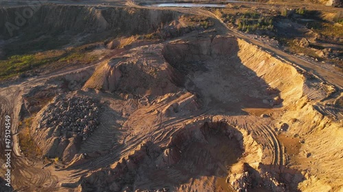 Opencast mine and mining industry concept. Flying over a drone over an open pit. Drone view of the sand pit. Aerial view of a mountain canyon with land structure after quarrying. photo
