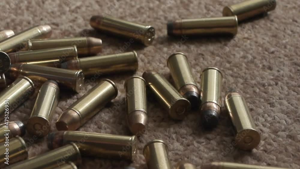 rifle cartridges close-up on the carpet. smooth camera movement rifle cartridges close-up on the carpet. smooth camera movement
