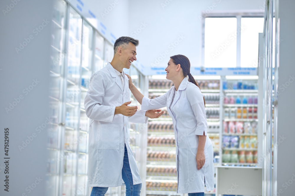 Two people in lab coats feeling good and smiling Two people in lab coats feeling good and smiling