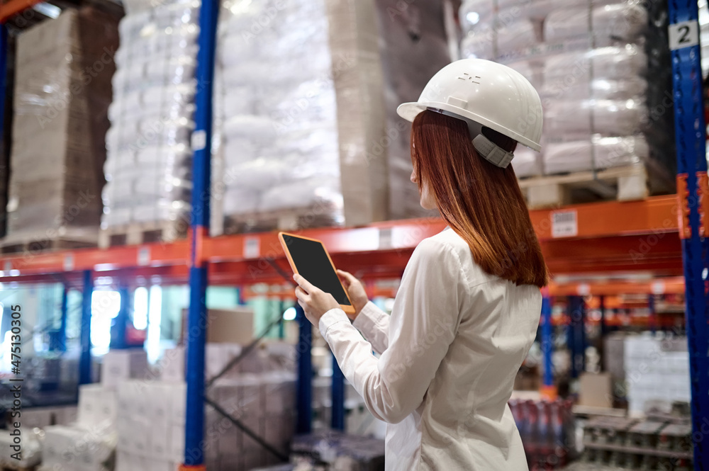 Profile of woman looking into tablet at warehouse
