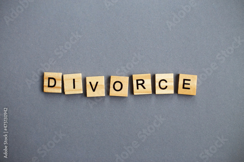 inscription divorce made by wooden blocks on gray background. broken family concept