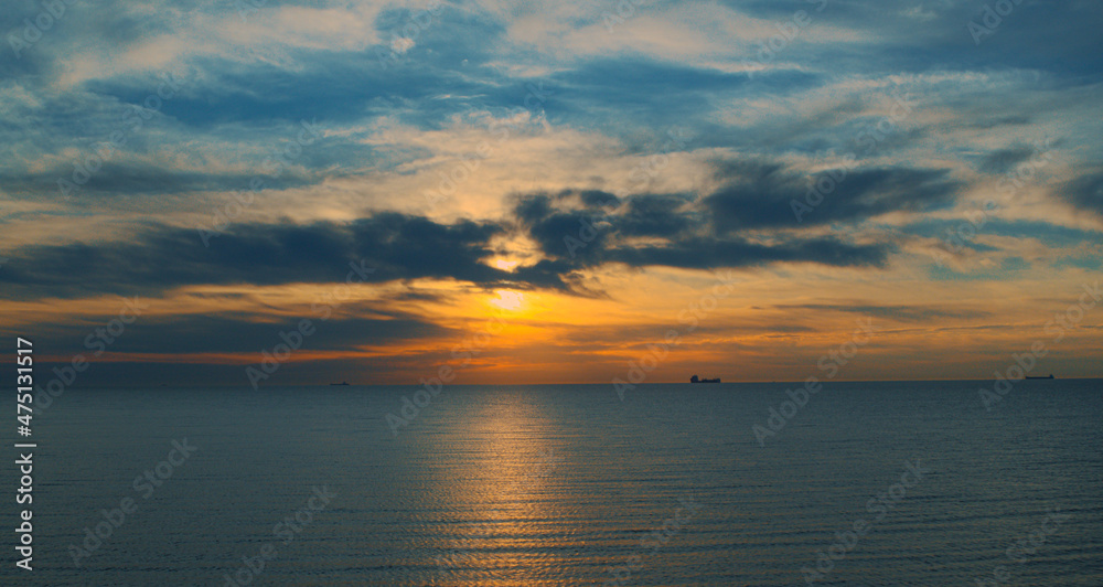 Charming orange sunrise reflecting in sea waves. Delightful seascape view.