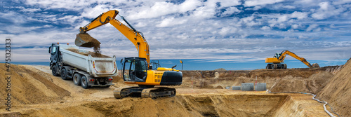 digger and excavator at work in construction site photo