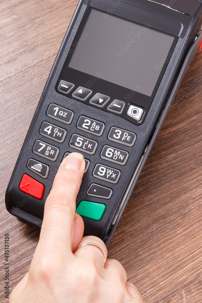 Hand of woman using credit card reader to enter PIN code. Cashless paying. Finance and banking Hand of woman using credit card reader to enter PIN code. Cashless paying. Finance and banking