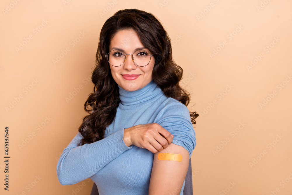 Obraz premium Photo of shiny charming lady dressed blue pullover glasses showing sticky plaster isolated beige color background