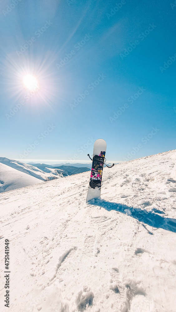 snowboard stick in snow mountains on background