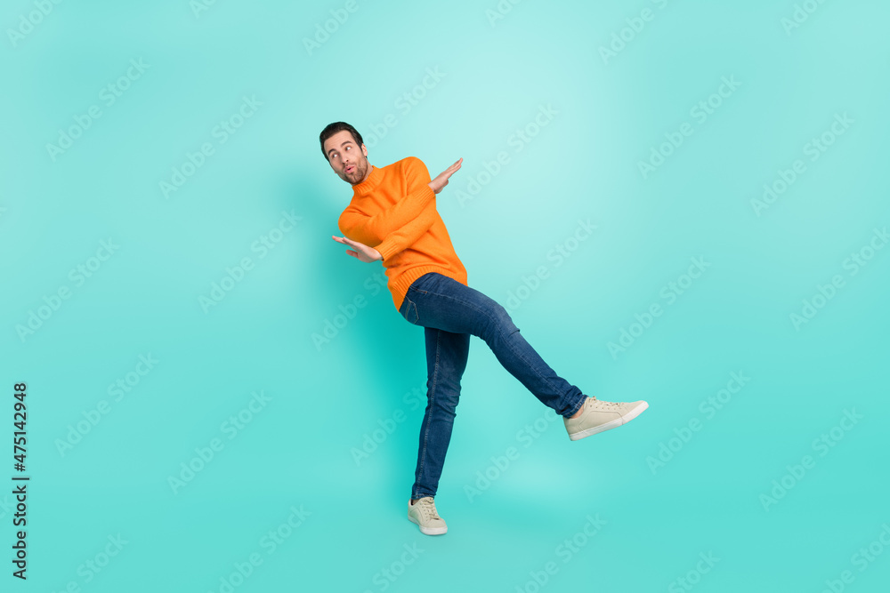 Full size photo of young man have fun chill clubber look empty space isolated over teal color background Full size photo of young man have fun chill clubber look empty space isolated over teal color background