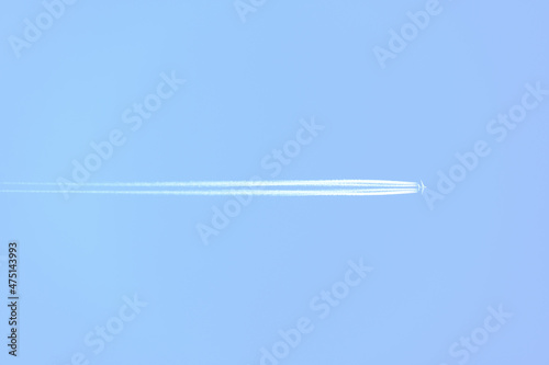 Traces and white streaks from the jet engines in the plane, white stripes in the sky.