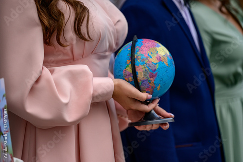 Teen girl holding a small globe, a copy of the earth in the hands of a child.