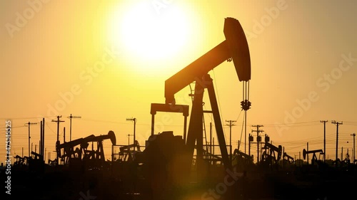 The sun rises behind oil pumps in California
