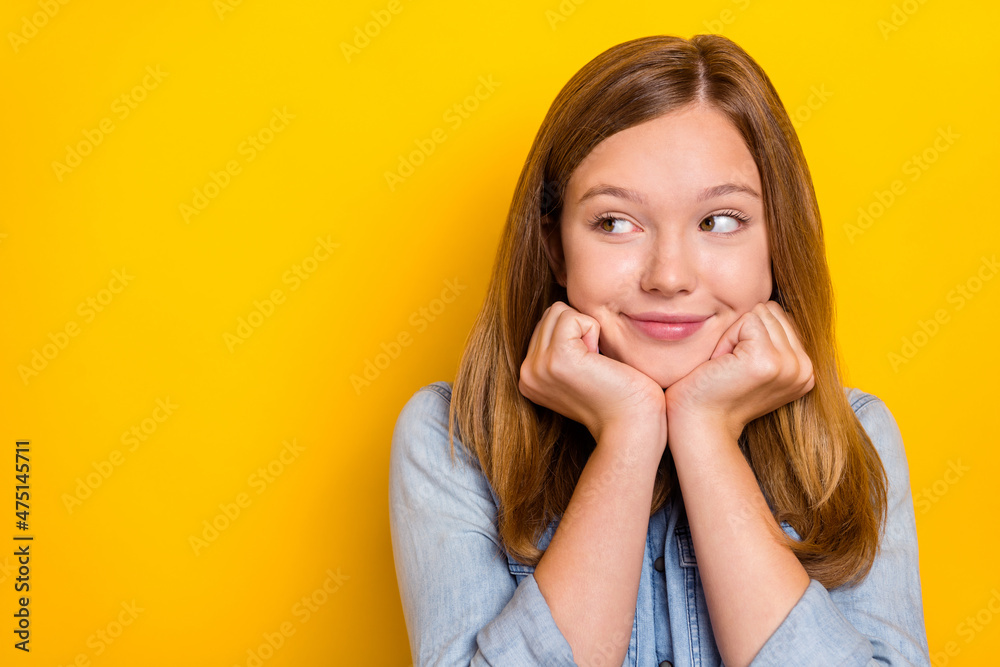 Photo of sweet teenager blond girl hands face look promo wear jeans outfit isolated on vivid yellow color background Photo of sweet teenager blond girl hands face look promo wear jeans outfit isolated on vivid yellow color background