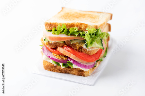 Fresh tasty sandwich with ham, tomato and red onion isolated on a white background.