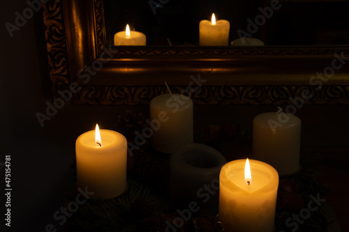 Burning candles in the dark reflected in a mirror