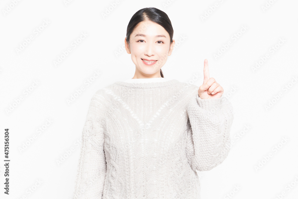 白い背景の前に立ってポイントを示す、セーターを着ている主婦 白い背景の前に立ってポイントを示す、セーターを着ている主婦