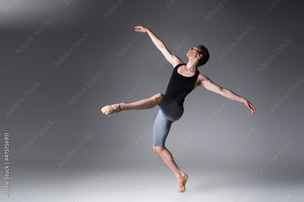 full length of young ballet dancer in black tank top on dark gray full length of young ballet dancer in black tank top on dark gray