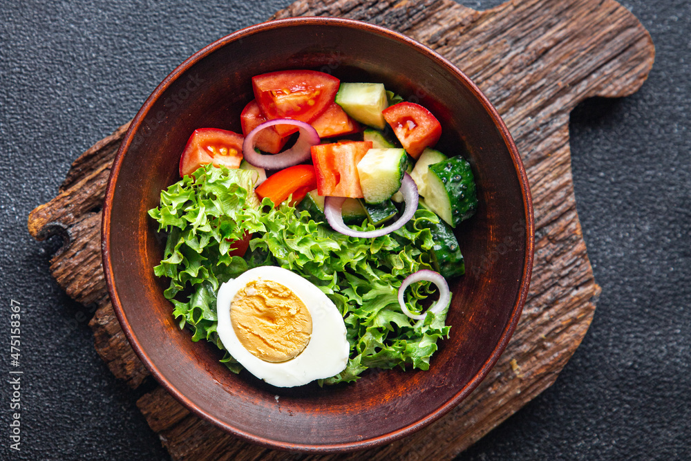 vegetables salad boiled egg cucumber, tomato, onion, lettuce healthy meal food diet snack on the table copy space food background rustic. top view keto or paleo diet
