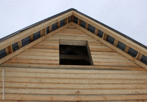 wooden unfinished house in the garden roof against the blue sky
