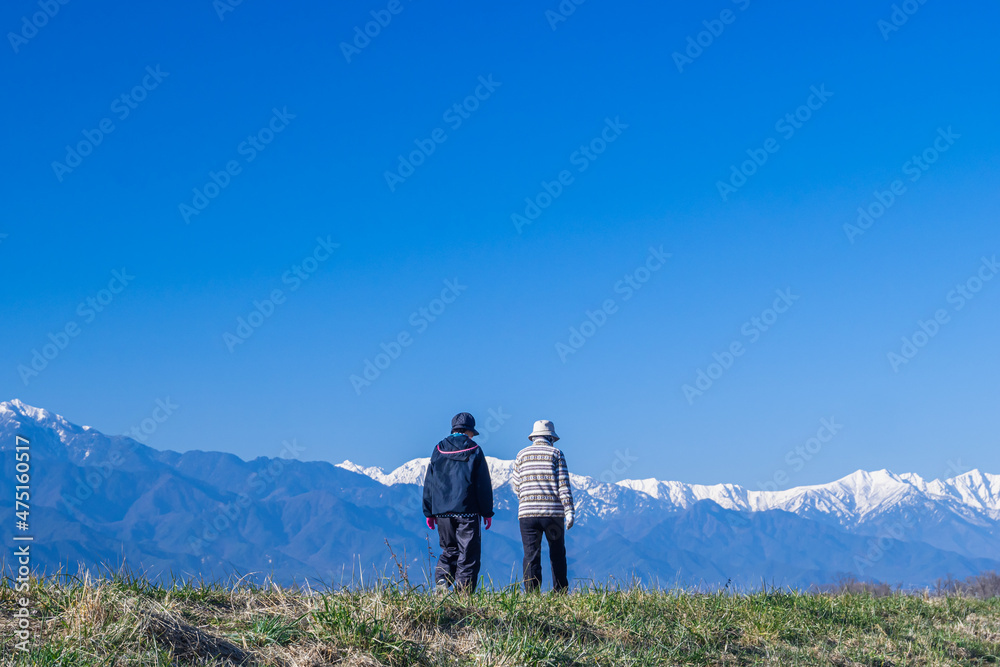 北アルプスを眺めながら散歩するシニア夫婦