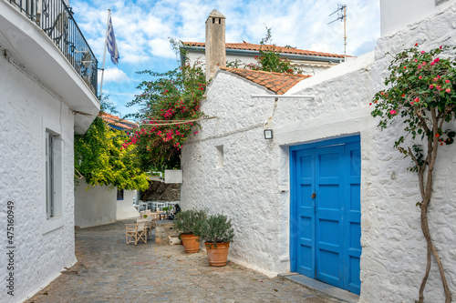 Fototapeta Naklejka Na Ścianę i Meble -  A picturesque street of whitewashed homes and a sidewalk cafe in the village of the small Greek island of Hydra, Greece.