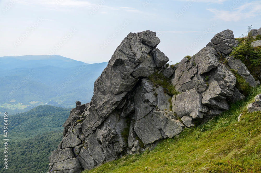 Rocks on Pikuy mount among green mountain hills covered in lush grass. Cloudy day in summer. Ukraine, Carpathian Mountains, Lviv region Rocks on Pikuy mount among green mountain hills covered in lush grass. Cloudy day in summer. Ukraine, Carpathian Mountains, Lviv region