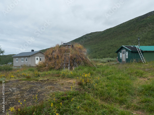 Sami village Staloluokta at Virihaure lake with houses and cottage, mountains and birch trees. summer moody and foggy day at Padjelantaleden hiking trail. Sweden Lapland landscape photo