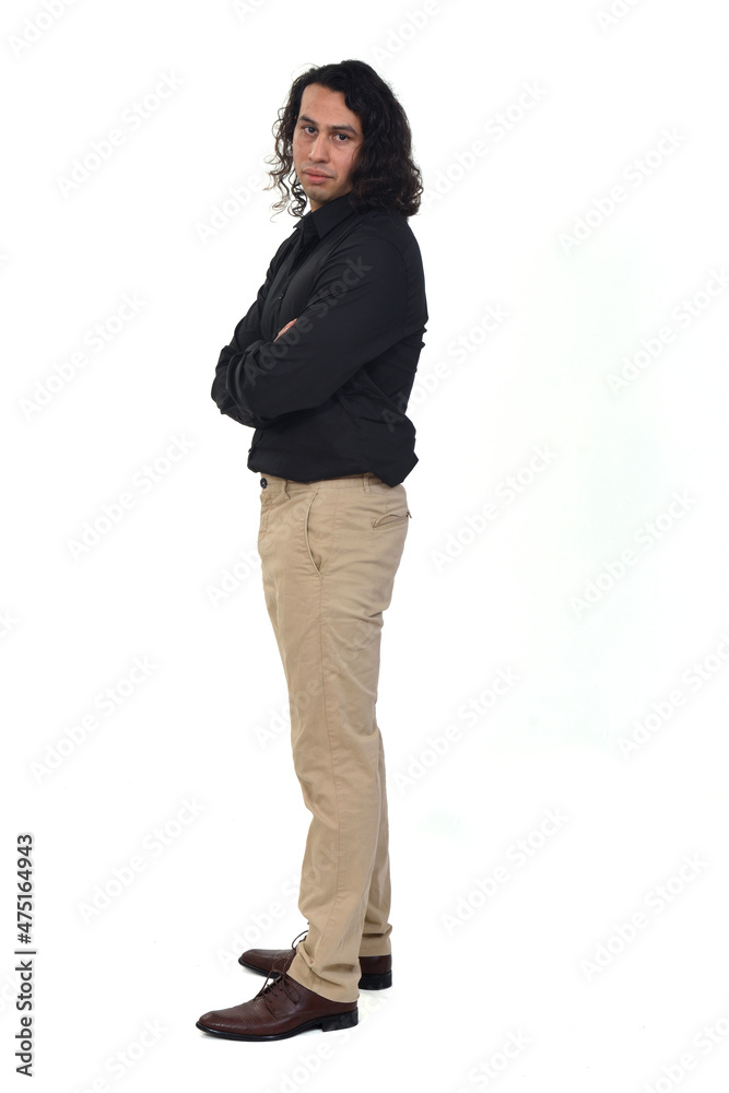 side view of a man with long hair looking at camera and arms crossed on white background side view of a man with long hair looking at camera and arms crossed on white background