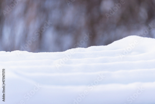 Snow covered bench in the park in winter. Close-up.