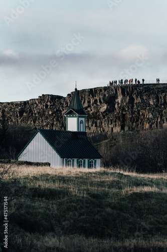 Vertical shot of the Thingvallakirkja church surrounded by rocky hills in Iceland photo