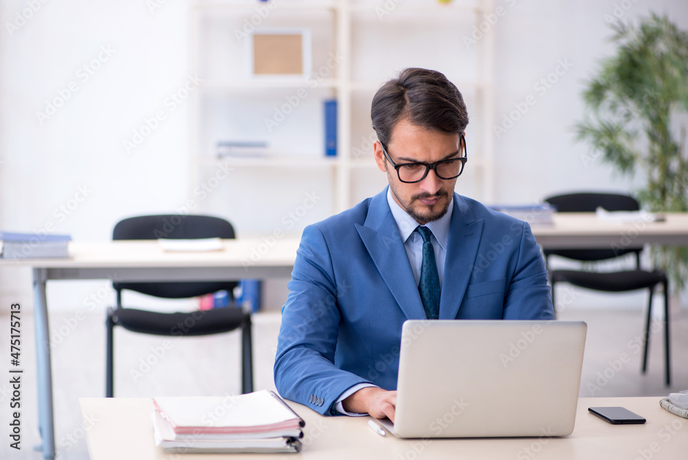 Young male employee working in the office Young male employee working in the office