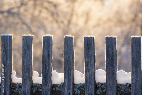 An old fence made of wood in the snow. Winter, frost.