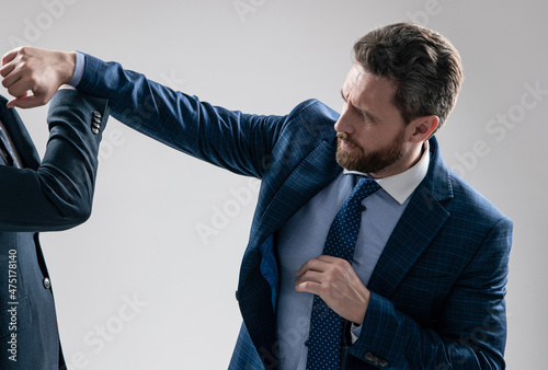 Aggressive professional man businessman punch coworker with fist grey background, fight