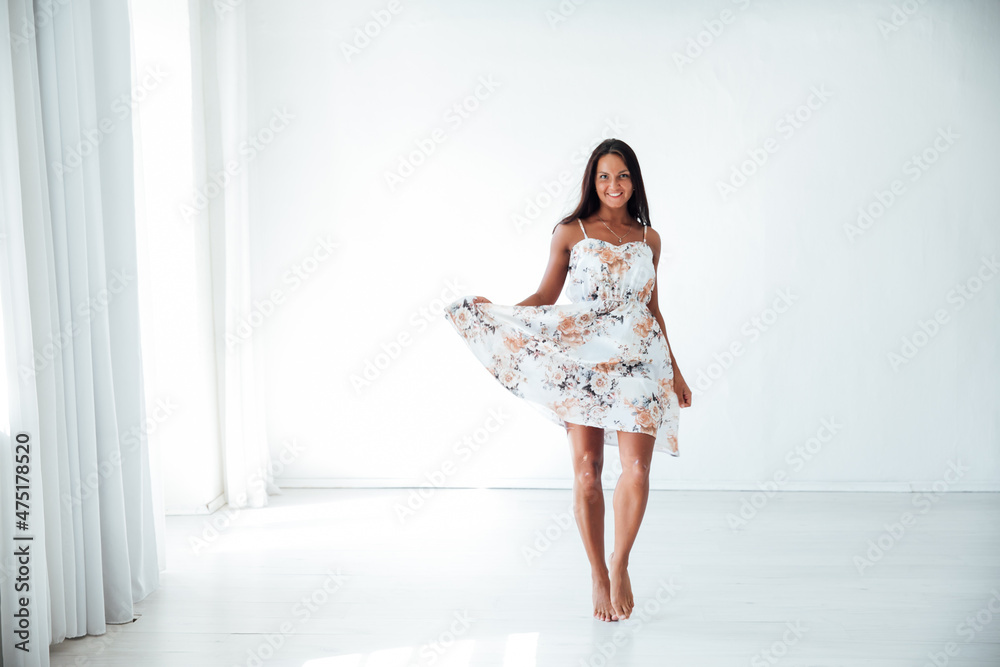 beautiful tanned woman in a summer dress in a white room beautiful tanned woman in a summer dress in a white room