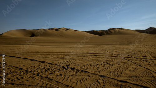 Sand dunes at the desert oasis of huacachina tourists take pictures and ride drive dune buggy sand board with guides before staying the night.