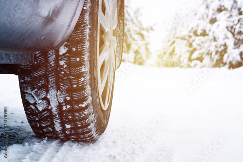 studded car tire on a winter snow-covered road in the forest, winter journey
