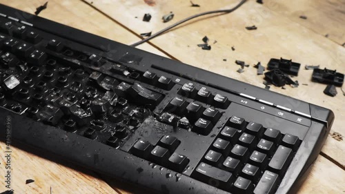 Hammer hitting computer keyboard. Damage keyboard. Broken office equipment. Old computer keyboard with smashed buttons. Garbage concept.