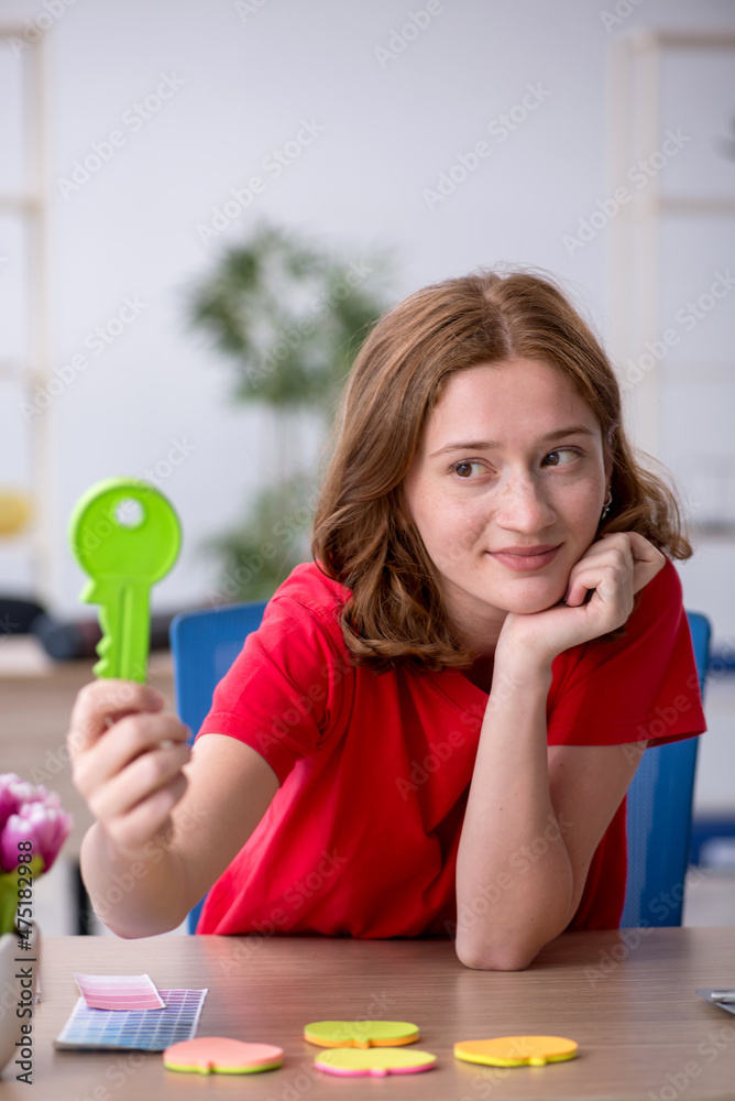 Young female designer holding big key in the office Young female designer holding big key in the office