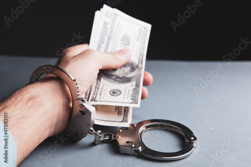 handcuffed man holding money