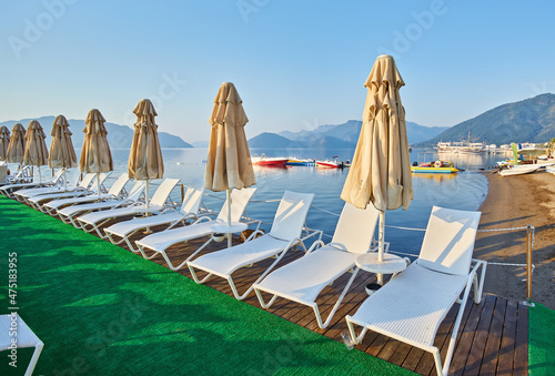 sandy beach without people and with sun loungers, umbrellas, palm trees, Marmaris