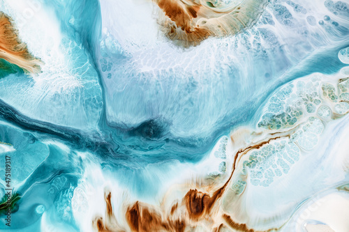 Acrylic texture with flowing paint colors blended with each other. Abstract fluid art backdrop with colorful waves and smooth shapes. Liquid image with cream effect of dyes mix.