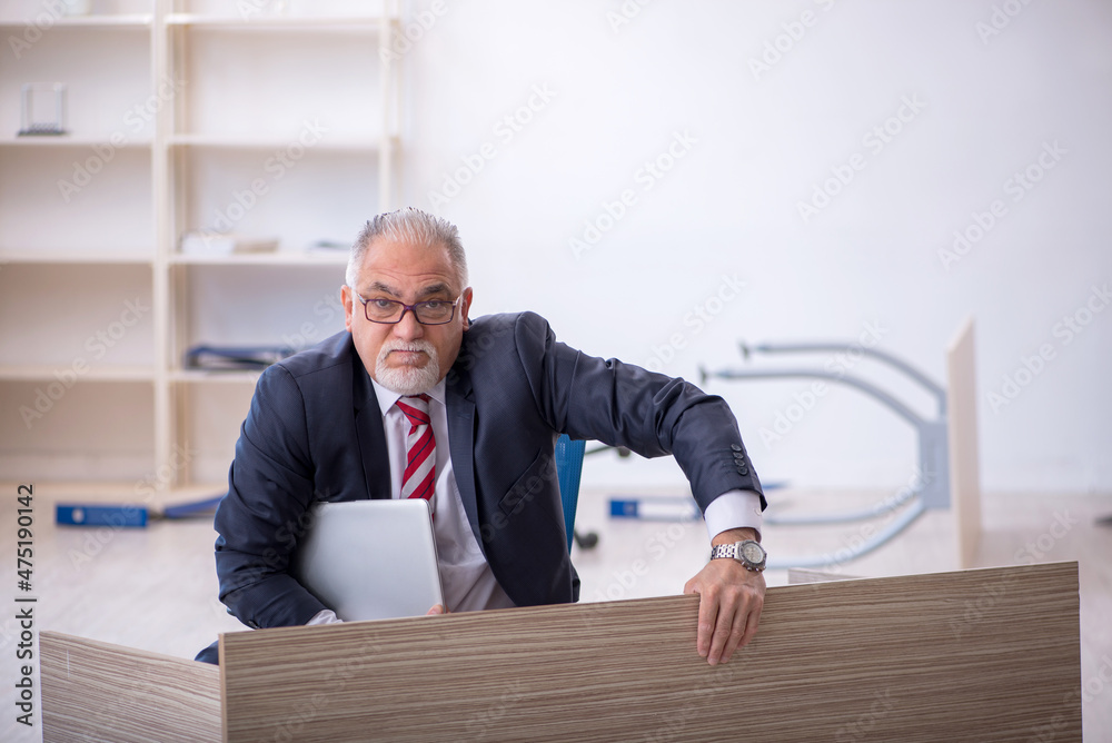 Old male employee working overtime in the office Old male employee working overtime in the office