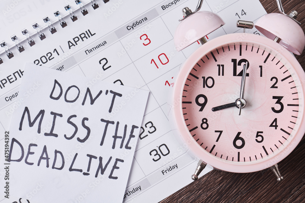 Dont miss the deadline. Deadline text on piece of paper, alarm clock and monthly calendar on the desk. White card with Deadline text and last date of month. Last day, Last chance concepts Dont miss the deadline. Deadline text on piece of paper, alarm clock and monthly calendar on the desk. White card with Deadline text and last date of month. Last day, Last chance concepts