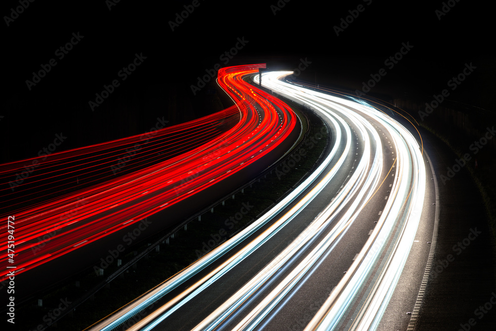 Multi-lane road at night with light trails from a long exposure, showing the moving traffic at rush hour. UK road or motorway, with blank area for copy space Multi-lane road at night with light trails from a long exposure, showing the moving traffic at rush hour. UK road or motorway, with blank area for copy space