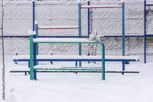 Empty sports playground with metal bars in the winter park for children and adults. Health benefits