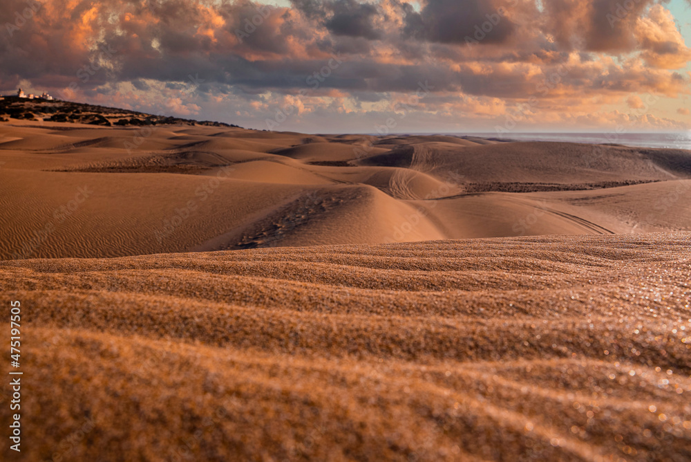 Scenic view of shiny sand dunes and seascape against dramatic cloudy sky Scenic view of shiny sand dunes and seascape against dramatic cloudy sky