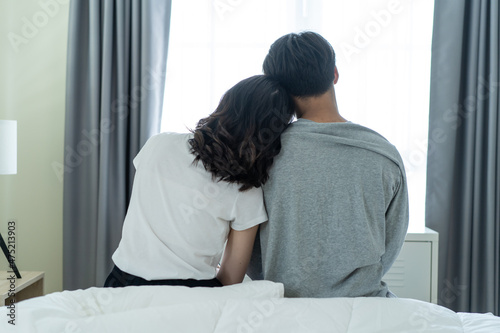 Rear view of Asian couple sitting together after wakeup in the morning