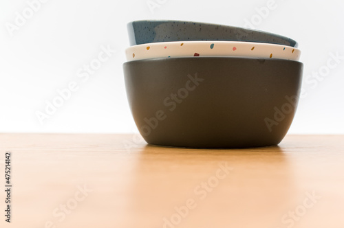Foto colorful piled up empty stoneware bowls on a wooden tabletop with copy space