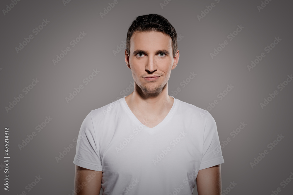man with an impish grinning on his face while looking at the camera and make a quite smile with his lips man with an impish grinning on his face while looking at the camera and make a quite smile with his lips