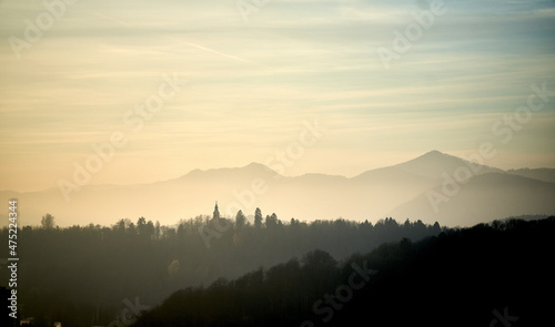 Scenic shot of a gorgeous autumn forest surrounded by high mountains photo